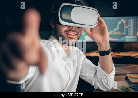 Lächelnd Geschäftsmann tragen VR-Brille berühren ar-Schnittstelle Zeigefinger an Kamera, glücklich Trader Trading online mit App in Headset Schutzbrille, Lager Stockfoto