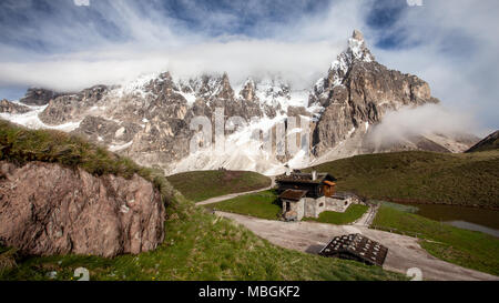 Cimon della Pala (auch genannt "Das Matterhorn der Dolomiten") mit schneebedeckten Gipfeln an einem sonnigen Tag mit dramatischen Wolken über. San Martino di Cas Stockfoto