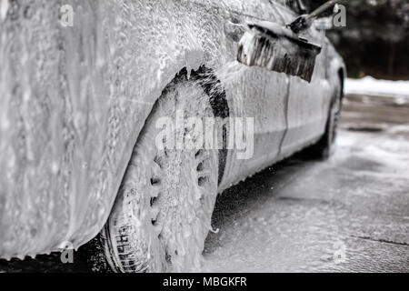 Auf dem Auto und Rad Detail, mit viel Seife, Bürste sprühen mehr Shampoo Schaum, wenn in der Waschstraße gewaschen. Stockfoto