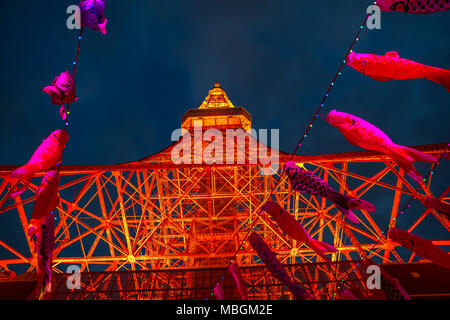 Tokyo, Japan - 23. April 2017: bunte Koinobori an der Tokyo Tower bei Nacht. Koinobori sind Karpfen-förmige wind Socken traditionell in Japan geflogen Kindertag feiern. Fokus auf den Tokyo Tower. Stockfoto