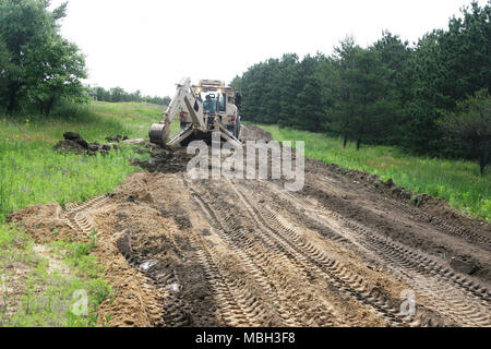 Ein Soldat mit Alpha Company, 766th Engineer Brigade Bataillon von Marseille, Illinois, verwendet eine hohe Mobilität Ingenieur Hydraulikbagger (HMEE) - einem Baggerlader entwickelt speziell für das US-Militär - eine Straße Juni 8, 2015 umzubauen, am Fort McCoy, Wis., die Arbeit ist Teil einer Truppe Projekt Straßen zu reparieren und Wanderwege auf Fort McCoy's South Post. Zahlreiche Soldaten aus der 766Th die HMEE, ein Sortierer verwendet, Muldenkipper, und mehrere andere Stücke von schwerem Gerät die Reparaturen abgeschlossen. Die 766Th ist ein Illinois National Guard Einheit, die im Rahmen der 33. Brigade Combat Team fällt und ist spezialisiert auf die Unterstützung von Stockfoto