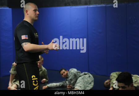 Us-Armee Sgt. Franklin Moore, zugeordnet zu der 55th Signal Company (Bekämpfung der Kamera) erläutert den Zweck von shrimping während des Basic Combatives Kurs an Gaffney Fitnesscenter am Fort George G Meade, Md., Dec 11, 2017. Die Army combatives Programm erweitert die Kampftruppe Bereitschaft, durch den Aufbau von persönlichen Mut, Vertrauen und Ausfallsicherheit sowie deren situative Reaktionsfähigkeit quartal Bedrohungen im betrieblichen Umfeld zu schließen. Stockfoto