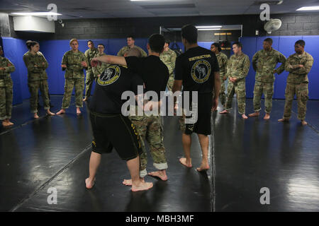 Us-Armee Pfc. Caitlyn Cassidy, zugeordnet zu der 55th Signal Company (Bekämpfung der Kamera) fragt eine Frage über die modifizierte Sicherheitsgurt Position während des Basic Combatives Kurs an Gaffney Fitnesscenter am Fort George G Meade, Maryland, Dec 11, 2017. Die Army combatives Programm erweitert die Kampftruppe Bereitschaft, durch den Aufbau von persönlichen Mut, Vertrauen und Ausfallsicherheit sowie deren situative Reaktionsfähigkeit quartal Bedrohungen im betrieblichen Umfeld zu schließen. Stockfoto