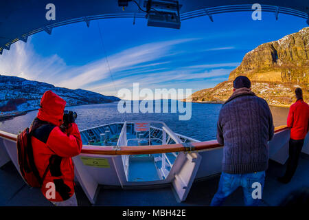 ALESUND, Norwegen - 09 April, 2018: Outdoor Ansicht von unbekannten Menschen Bilder nehmen an der Vorderseite des Schiffes Kreuzfahrt mit Hurtigruten Stockfoto