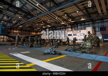 Us-Flieger und Soldaten in die 435Th Contingency Response Group, 4 Air Support Operations, 2 Air Support Operations Squadron, und der US-Armee Garnison Rheinland-Pfalz Dawn ihre Fallschirme in Ramstein Air Base, Deutschland, 29. März 2018 zugeordnet. Die Mitglieder hatten ihre Gang durch jumpmasters vor dem Einstieg in das Flugzeug kontrolliert. Stockfoto