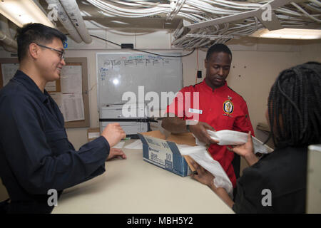 Mittelmeer (2. April 2018) Fachkraft für Lagerlogistik Seaman Beau Hernandez (links), aus San Francisco, hilft Kulinarische Specialist 2. Klasse Stephen Fuqua, aus Flint, Michigan, und US Marine Corps Cpl. Akugarba Aunice, von Bowie, Md. und für die Luftfahrt Combat Element des 26 Marine Expeditionary Unit, Beschaffung von Verbrauchsmaterialien in der Supply Shop an Bord der San Antonio-Klasse amphibious Transport dock Schiff USS New York (LPD 21) April 2, 2018. New York, homeported in Mayport, Fla., ist die Durchführung von naval Operations in den USA 6 Flotte Bereich der Operationen. Stockfoto