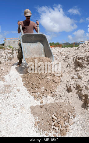 Builder 3. Klasse Cooper Desario, Naval Mobile Konstruktion Bataillon (NMCB) 11, Det zugeordnet. Guam, dumps Schmutz für die Gründung einer Toilette und Dusche auf Polaris, April 5, 2018. NMCB 11, Det. Guam bietet expeditionary Bau und Engineering Wartung und Betrieb der expeditionary Basen und Einrichtungen, taktische sustainment Bridging, humanitäre Hilfe durch den Bau des staatsbürgerlichen Engagements Details und civic Action Teams und Theater disaster response Funktionen in den USA 7 Flotte Gebiet zu gehören. Stockfoto