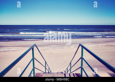 Eine Treppe führt zu einem leeren Strand, Farbe getonte Bild. Stockfoto