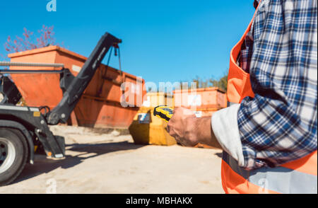 Mann Laden von Bauschutt Container auf Lkw Stockfoto