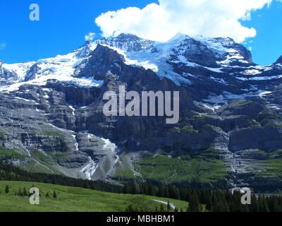 Blick auf die Alpen Reihe Landschaften in der Nähe von Grindelwald Dorf in der Schönheit der Schweizer Alpen in der Schweiz, schneebedeckten Gipfeln, grasbewachsenen Felder, klare blaue Stockfoto