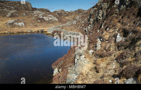 Ungewöhnliche Mauer aus Stein gebaut aus Granit Felsen schlängelt sich durch die felsige Landschaft von Uig auf der Isle of Lewis in Schottland. Stockfoto