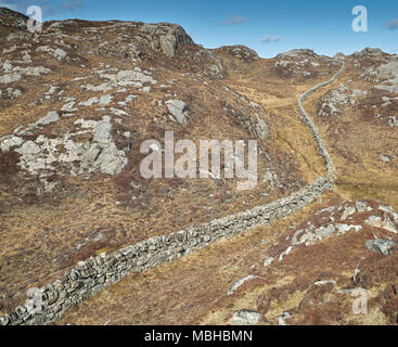 Ungewöhnliche Mauer aus Stein gebaut aus Granit Felsen schlängelt sich durch die felsige Landschaft von Uig auf der Isle of Lewis in Schottland. Stockfoto