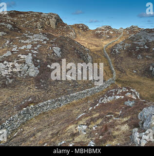 Ungewöhnliche Mauer aus Stein gebaut aus Granit Felsen schlängelt sich durch die felsige Landschaft von Uig auf der Isle of Lewis in Schottland. Stockfoto