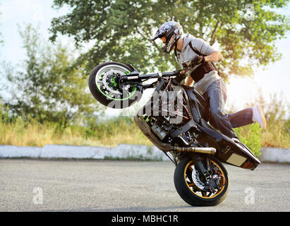 Ternopil, Ukraine - 28. August 2015: junge Biker ist, der seine Talente von doingdangerous Tricks auf seinem Sport Motorrad. Er reitet auf Sommer Straße der Stadt. Stockfoto