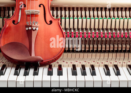 Classic Brown Violine in der Nähe Bild von Grand Piano keys und Interieur mit Streichern, Hammer und Struktur Hintergrund Stockfoto