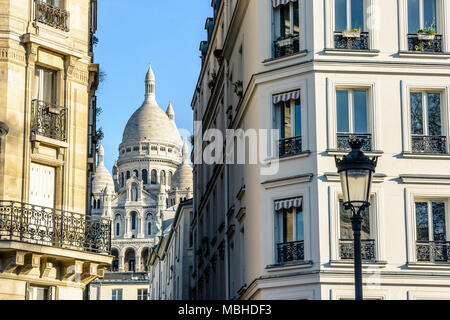 Die Basilika des Heiligen Herzen von Paris durch eine enge Straße zwischen typischen Gebäude mit einem Vintage Straße Licht im Vordergrund. Stockfoto