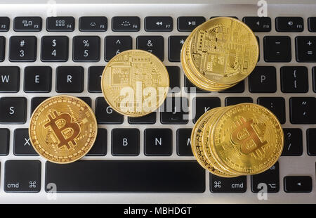 Bitcoins auf der Tastatur eines Laptops Stockfoto