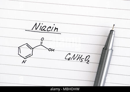 Die chemische Formel von Niacin auf liniertem Papier mit schwarzem Stift. Close-up. Stockfoto