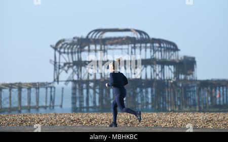 Brighton. 11. April 2018. UK Wetter: ein Läufer geht durch das verlassene West Pier von Brighton direkt am Meer an einem schönen sonnigen Morgen entlang der Südküste mit der Wettervorhersage bis in Großbritannien in den nächsten Tagen warm. Viele Läufer sind in der Ausbildung für den Brighton Marathon, der findet am kommenden Sonntag: Simon Dack/Alamy leben Nachrichten Stockfoto