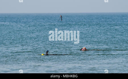 Brighton. 11. April 2018. UK Wetter: Schwimmer und ein Paddel boarder aus Brighton Beach genießen Sie einen schönen sonnigen Morgen entlang der Südküste mit der Wettervorhersage bis in Großbritannien in den nächsten Tagen Gutschrift zu warm: Simon Dack/Alamy leben Nachrichten Stockfoto