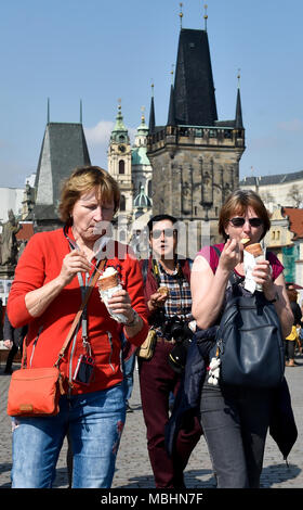 Prag, Tschechische Republik. 11 Apr, 2018. Touristen Spaziergang auf der Karlsbrücke in Prag, Tschechische Republik, am 11. April 2018. Auf dem Hintergrund der Mala Strana Bridge Tower gesehen. Quelle: Vit Simanek/CTK Photo/Alamy leben Nachrichten Stockfoto