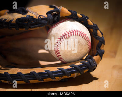 Close up Sport Hintergrund Bild eines alten verwitterten Leder Baseball mit Red Laces innerhalb eines Baseball Handschuh oder mitt mit komplizierten Details Stockfoto