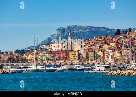 Ausblick auf den kleinen Hafen mit Yachten und alten bunten Häuser der Altstadt im Hintergrund in Menton - beliebter Ferienort an der Französischen Riviera. Stockfoto
