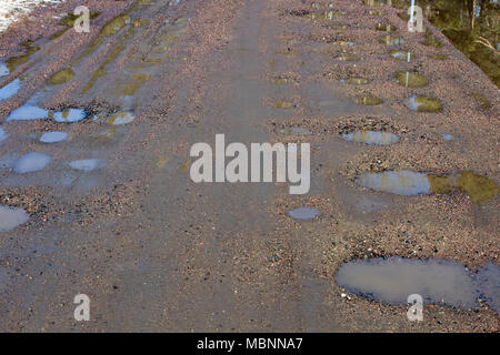 Feuchter Schmutz Straße mit Pfützen im Frühjahr, Finnland Stockfoto