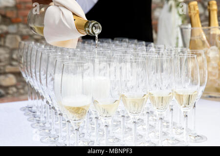 Nahaufnahme einer Hochzeitsfeier, ein Kellner gießt etwas Sekt für die Gäste Stockfoto