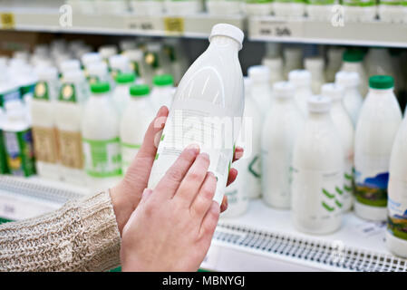 Frau entscheidet, Milch und Milchprodukte im Supermarkt Stockfoto