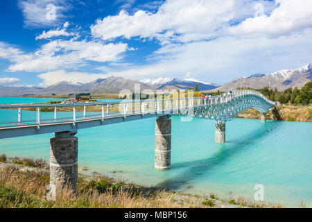 Neuseeland Südinsel Neuseeland Touristen auf der Fußgängerbrücke über den Lake Tekapo outlet Scott Teich Lake Tekapo mackenziedistrict Stockfoto