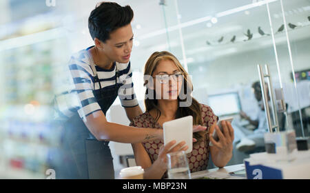 Kreative Unternehmerinnen mit Smart Phone und digitale Tablette im Büro Stockfoto