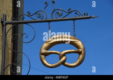 Eine antike metallische Shop - Schild in Form eines goldenen Brezel in der Altstadt von Füssen, Bayern, Deutschland Stockfoto