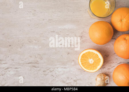 Blick von oben auf die Orangen und Orangensaft auf Marmor tisch Stockfoto
