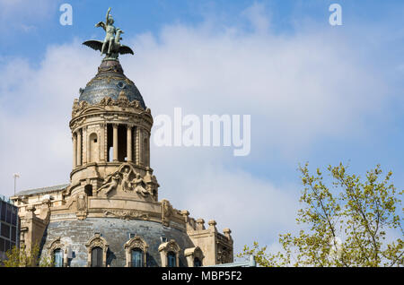 Eine Abbildung mit einem geflügelten Vögel sitzen auf der Spitze der Kuppel an der Spitze eines Gebäudes auf dem Passeig de Gràcia in Barcelona, Spanien. Stockfoto