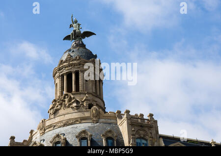 Eine Abbildung mit einem geflügelten Vögel sitzen auf der Spitze der Kuppel an der Spitze eines Gebäudes auf dem Passeig de Gràcia in Barcelona, Spanien. Stockfoto