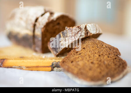 In der Nähe von Brot in Stücke schneiden liegt auf einem Schneidebrett Stockfoto