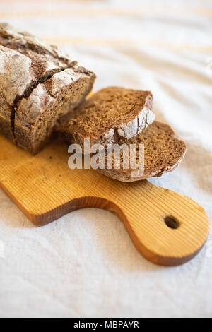 Geschnittenes Brot auf dem Schneidebrett Stockfoto