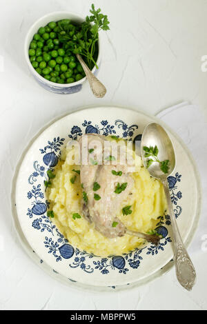 Kaninchen in saurer Sahne Soße mit Kartoffelpüree und Erbsen. Im rustikalen Stil. Stockfoto