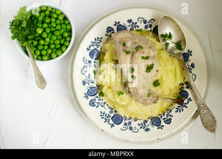 Kaninchen in saurer Sahne Soße mit Kartoffelpüree und Erbsen. Im rustikalen Stil. Stockfoto