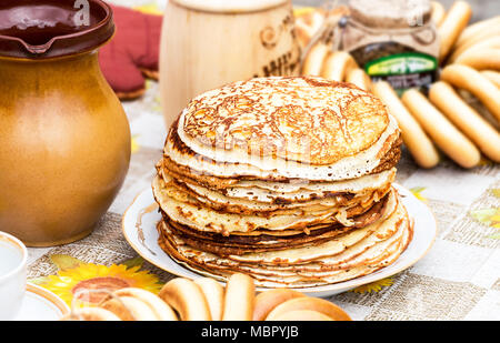 Russische traditionelle Lebensmittel. Stapel von leckeren gebratenen Pfannkuchen und Bagels auf die Tabelle während der FASTNACHTSWOCHE Stockfoto