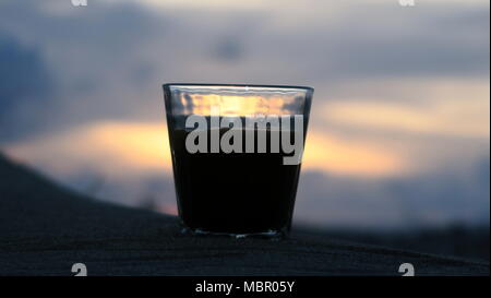 Silhouetten von Kaffee am Strand bei Sonnenuntergang Stockfoto