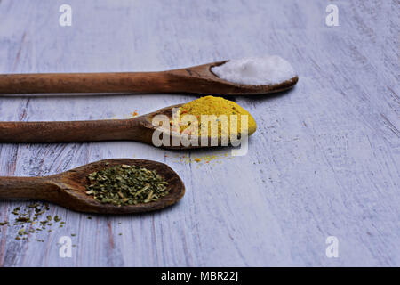 Bunten Gewürzen in Löffel auf weißem Hintergrund Holz, Top View/Küche - Essen Hintergrund Stockfoto