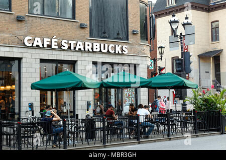 Quebec, Kanada. Die Leute auf dem Bürgersteig Terrasse von Starbucks Cafe auf St-Denis Street in der Innenstadt von Montreal sitzen. Stockfoto