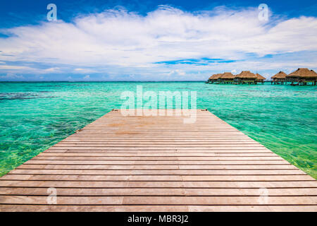 Hölzerner Steg oder Pier über der tropischen blauen Lagune in Moorea, Französisch-Polynesien. Stockfoto