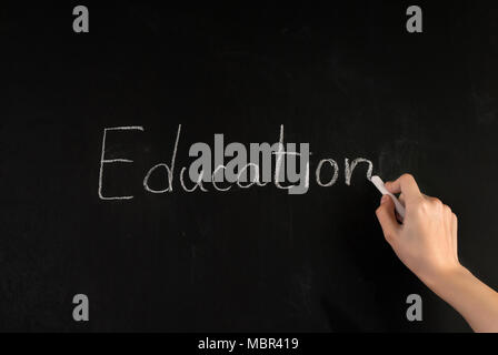 Weibliche Hand schreiben Wort Bildung auf der Schule Tafel mit weißer Kreide Stockfoto