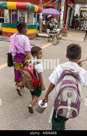 Yangon, Myanmar - 26. September 2016: Unbekannter burmesischen Frau, die ihre Kinder in der Schule. Yangon street scene. Stockfoto