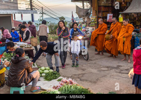 Mae Salong, Thailand - Februar 8, 2017: Morgen Straßenszene in Mae Salong Dorf in Nord-thailand. Thailändische Mönche Sammeln von Almosen und Angebote, die auf der Lo Stockfoto