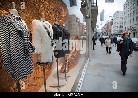 Exklusive kleidung shop Fenster von Dior auf New Bond Street in Mayfair, London, England, Vereinigtes Königreich. Bond Street ist eine der wichtigsten Straßen im West End Einkaufsviertel und ist sehr gehobene. Es hat einen modischen Shopping Street seit dem 18. Jahrhundert. Die reichen und wohlhabenden Shop hier meist für High End Fashion und Schmuck. Stockfoto