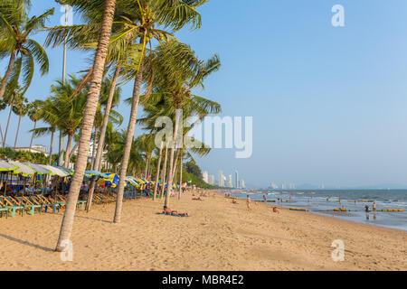 Pattaya, Thailand - 6. März 2017: Strand in Pattaya mit Palmen und Wolkenkratzer auf Hintergrund. Stockfoto